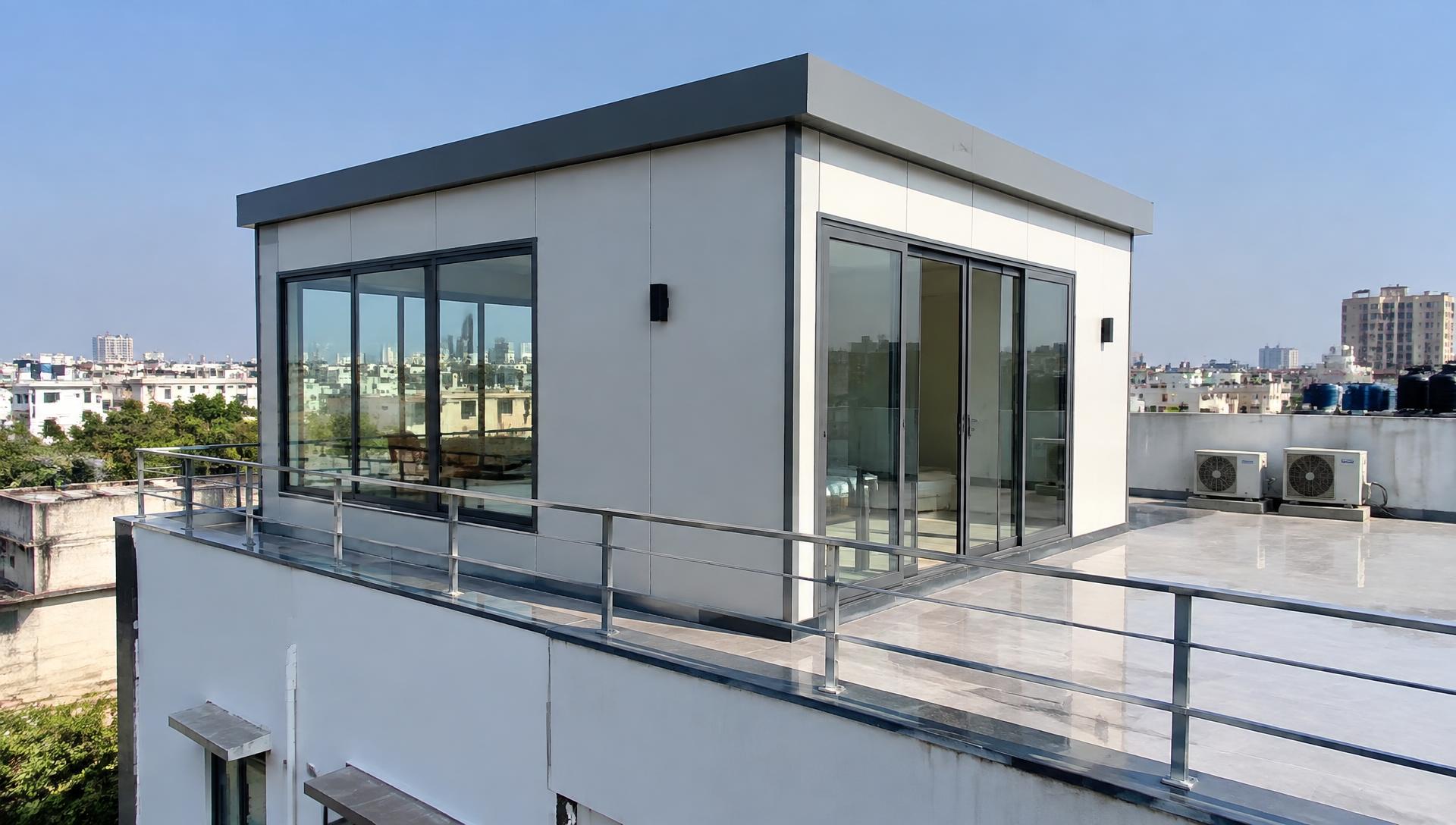 Modern prefabricated rooftop room with glass doors installed on an urban terrace